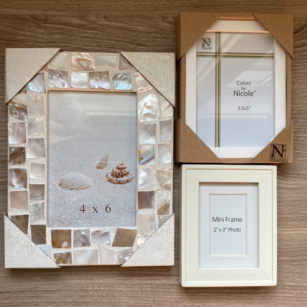 Three white frames one with shells bundle